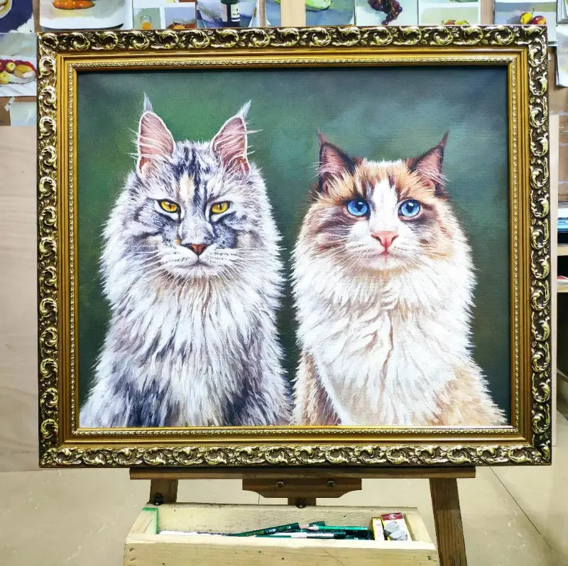 A bespoke, 100% hand-painted oil portrait of a Maine Coon and a Ragdoll cat, displayed in an ornate gold frame, created as a custom pet keepsake by Muse & Paw.