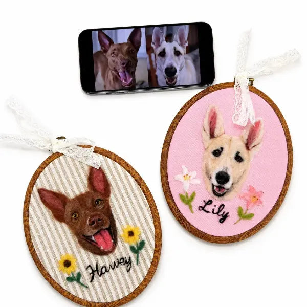 Handmade personalized double dog portrait hoop art featuring custom wool felted dog heads on striped and pink fabrics with embroidered sunflower, lily flowers, and personalized pet names.