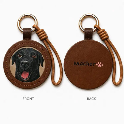 Handmade personalized dog portrait key ring displaying a premium brown leather tag with a custom black lab oil painting replica charm, unique luxury memorial gift for pet lovers.