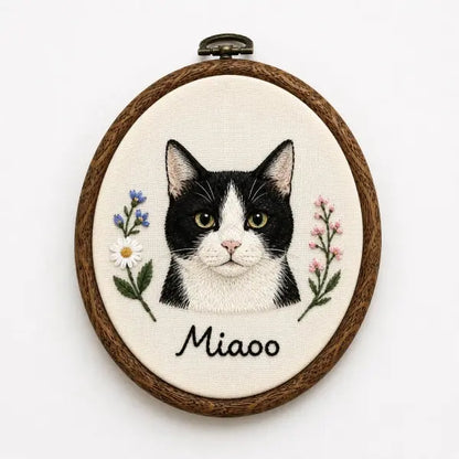 Personalized handmade tuxedo kitten stitched portrait on off-white linen, styled as a vintage oval wall hanging keepsake with custom lettering for a luxury cat mom birthday gift.