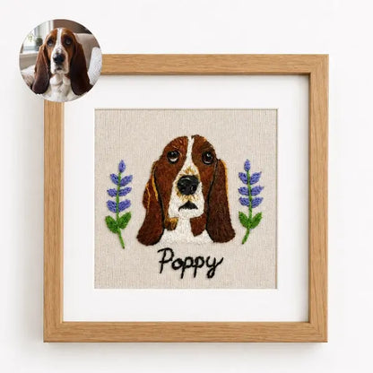 Custom dog photo to embroidery art in a wooden frame, featuring a realistic stitched portrait of a Basset Hound named Poppy with sad hound eyes, long floppy ears, and embroidered purple lavender flowers.