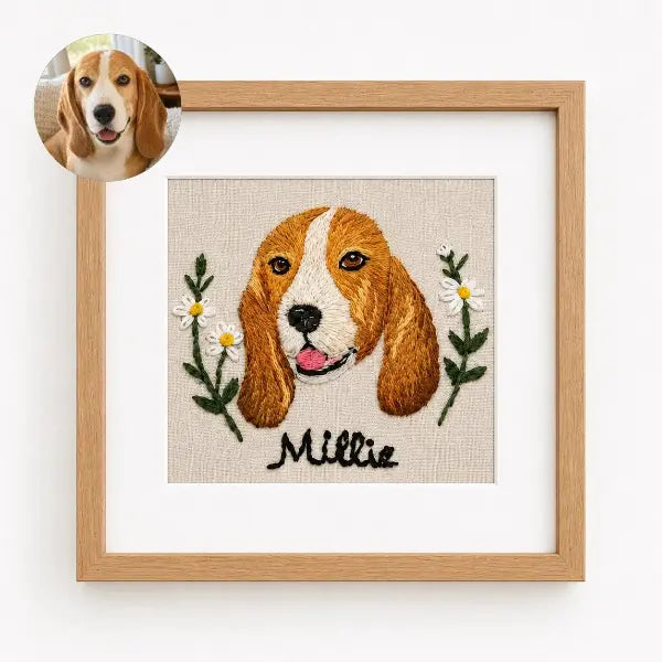Custom dog photo to embroidery art in a wooden frame, featuring a realistic stitched portrait of a Beagle named Millie with brown and white fur, floppy ears, and embroidered daisy flowers.