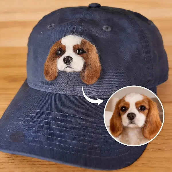 Custom pet photo to hat comparison, showing a real Cavalier King Charles Spaniel dog photo transformed into a handmade 3D needle-felted portrait on a navy blue baseball cap.
