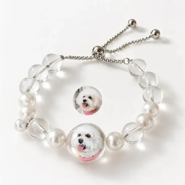 Custom pet photo to jewelry comparison, showing a real white Bichon Frise dog photo transformed into a hand-painted miniature portrait on a beaded pearl bracelet.