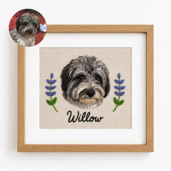 Custom dog photo to embroidery art in a wooden frame, featuring a realistic stitched portrait of a curly grey and black Doodle mix named Willow with detailed fluffy fur texture and embroidered lavender flowers.