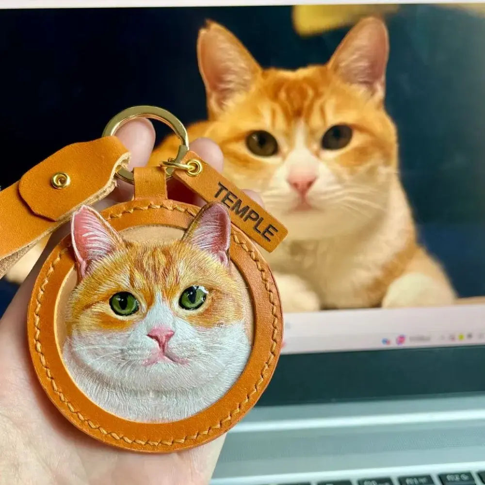 Hand-carved leather orange tabby cat keychain with custom name tag, personalized pet portrait leather bag charm by Muse & Paw.